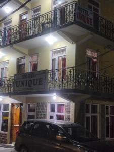 HOTEL UNIQUE في مانالي: سيارة سوداء متوقفة أمام مبنى