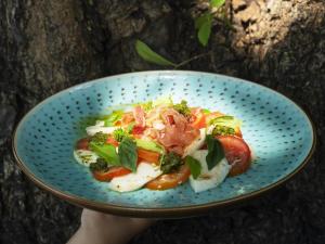 a blue bowl of food with broccoli and tomatoes at Explorar Koh Phangan - Adults Only Resort and Spa in Haad Rin