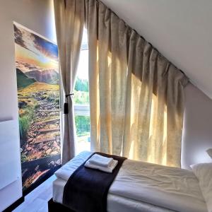 1 dormitorio con cama y ventana en MotoChillout dom"Dukat" en Polańczyk