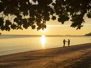 a couple walking on the beach at sunset at Explorar Koh Phangan - Adults Only Resort and Spa in Haad Rin