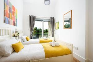 2 camas en un dormitorio con amarillo y blanco en Roseberry Cottage - Lower Mill Estate, en Somerford Keynes