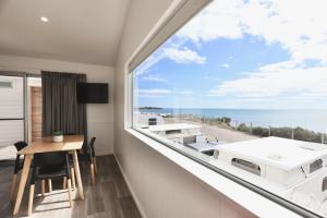 a room with a large window and a table with a view at Sea Vu Caravan Park in Robe