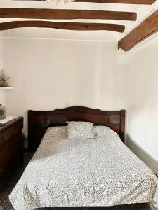 um quarto com uma cama de madeira e um tecto de madeira em Casa de Turisme Rural Riu Montsant em Bellmunt de Ciurana