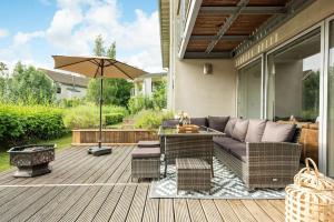 a patio with a couch and a table and an umbrella at Roseberry Cottage - Lower Mill Estate in Somerford Keynes +54 photos