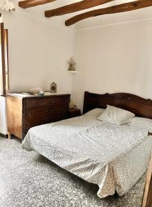 1 dormitorio con cama y tocador de madera en Casa de Turisme Rural Riu Montsant, en Bellmunt de Ciurana