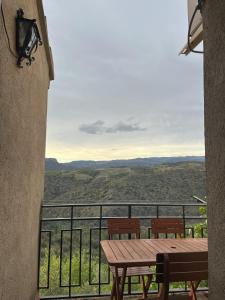 uma mesa e bancos numa varanda com vista em Casa de Turisme Rural Riu Montsant em Bellmunt de Ciurana