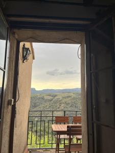 uma porta aberta para uma varanda com uma mesa e cadeiras em Casa de Turisme Rural Riu Montsant em Bellmunt de Ciurana