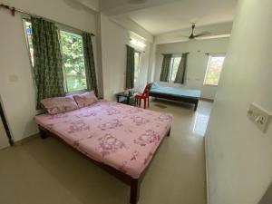 a bedroom with a pink bed in a room at Sandhya Guest House in Digha