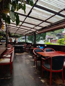 a restaurant with tables and chairs under a roof at Jungle Ippie Hostel in Tanah Rata