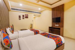 pokój hotelowy z 2 łóżkami i telewizorem z płaskim ekranem w obiekcie FabHotel Ginger Suites w mieście Bengaluru