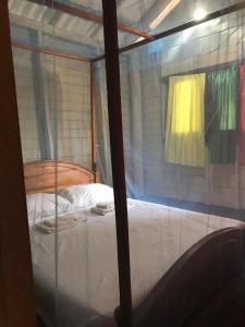 a bed in a room with a glass window at Ocean View Cabana in Pottuvil