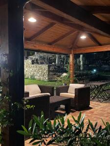 eine Terrasse mit Korbstühlen und Tischen unter einem Pavillon in der Unterkunft Casa Natura 40 in Parghelia
