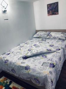 a bed with a blue and white comforter on it at Studio apartament in Arad