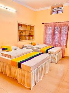 um quarto com três camas num quarto em North Star Home Stay Mysore em Mysore