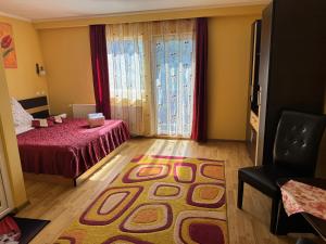 a bedroom with a bed and a rug on the floor at Pensiunea Dorali in Moieciu de Jos
