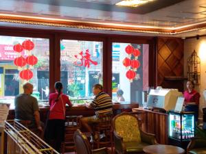 a group of people sitting at a bar in a restaurant at Phuminh Hotel Riverside in Phnom Penh