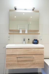 a bathroom with a sink and a mirror at Luv in Juist +12 photos
