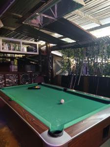 a pool table with a ball on top of it at Jungle Ippie Hostel in Tanah Rata