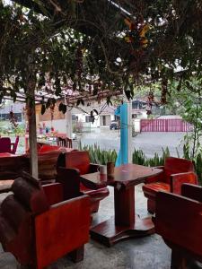 un patio con sillas, mesas, mesa y sillas en Jungle Ippie Hostel, en Tanah Rata
