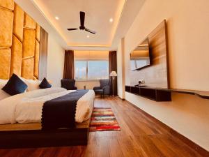Habitación de hotel con cama y ventilador de techo. en Hamshu Cafe & Stay, en Kota