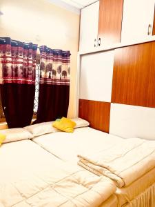 a bedroom with two beds and curtains in it at North Star Home Stay Mysore in Mysore