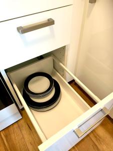 a stack of plates sitting in a drawer of a cabinet at Location Location Vacation in Fremantle