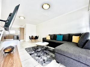 a living room with a couch and a table at TK’s Penthouse - The Blyde in Pretoria