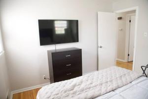 - une chambre avec un lit et une télévision murale dans l'établissement Inviting 2BR Lower Duplex Near Everything, à Glendale