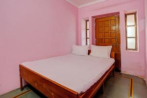 a bedroom with a bed with white sheets and a window at OYO Hotel Neelkamal palace and Guest house in Nāthdwāra