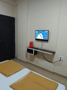 a living room with a tv on a wall at Samraj Lodge in Akalkot