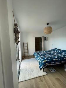 Schlafzimmer mit einem Bett mit blauer Decke in der Unterkunft Maison 4 CH proche de la mer in Aytré