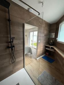 ein Bad mit einer Dusche und einer Glastür in der Unterkunft Maison 4 CH proche de la mer in Aytré
