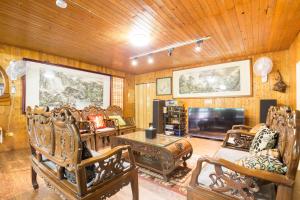 a living room filled with furniture and a flat screen tv at Song Hua Ju B&B in Heping