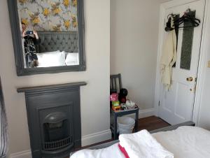 Dublin canal side في دبلن: غرفة نوم مع موقد ومرآة على الحائط