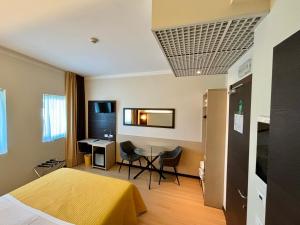 メストレにあるホテル アルヴェリのベッドとテーブルが備わるホテルルームです。
