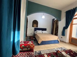 1 dormitorio con 1 cama con techo azul en pyramids view Guest villa en Al Mazghūnah