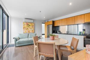 cocina y sala de estar con mesa y sillas en Superb 1-Bed CBD Pad with Private BBQ Area, en Melbourne