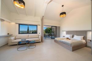 a bedroom with a bed and a couch and a table at The "L" Suites & Apartments in Argostoli
