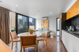 cocina y sala de estar con mesa y sillas en Superb 1-Bed CBD Pad with Private BBQ Area, en Melbourne