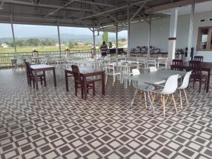 a dining room with tables and chairs on a tiled floor at LOSMEN 88 in Ratodena