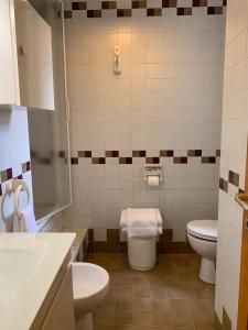 ein Badezimmer mit 2 WCs und einem Waschbecken in der Unterkunft Appartamento Dei Pini in Milano Marittima