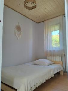 Habitación blanca con cama y ventana en Noclegi u izy en Ustrzyki Dolne