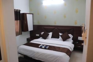 ein Schlafzimmer mit einem großen Bett mit weißen und braunen Kissen in der Unterkunft Hotel shivalay palace in Maheshwar