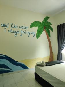 a bedroom with a palm tree sticker on the wall at Jungle Ippie Hostel in Tanah Rata