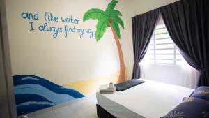 a bedroom with a palm tree stenciled on the wall at Jungle Ippie Hostel in Tanah Rata