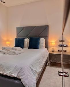 a bedroom with a large white bed with blue pillows at Luxury 2 Bedroom Apartment in Old Street, London in London