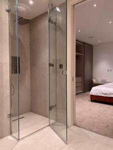 a glass shower in a bedroom with a bed at Luxury 2 Bedroom Apartment in Old Street, London in London