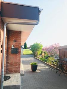 a patio with a brick building and a potted plant at Ferienbungalow mit Terrasse - Familie Kader in Eckernförde