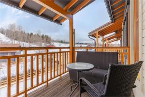 a porch with two chairs and a table on a balcony at KungsbergetNatur in Järbo