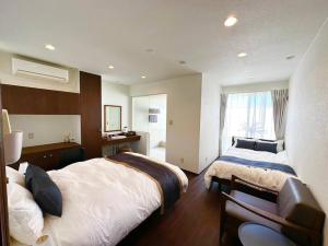 a hotel room with two beds and a window at Nexus Ishinomakiokaidou in Ishinomaki